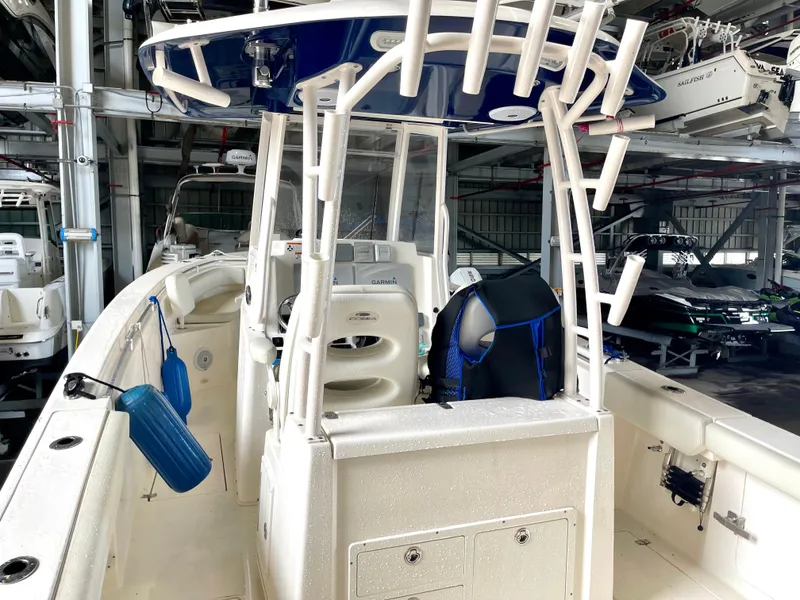 Slide: The Image of 2018 Cobia 301 Center Console boat in storage, featuring a spacious deck and modern amenities. - 11