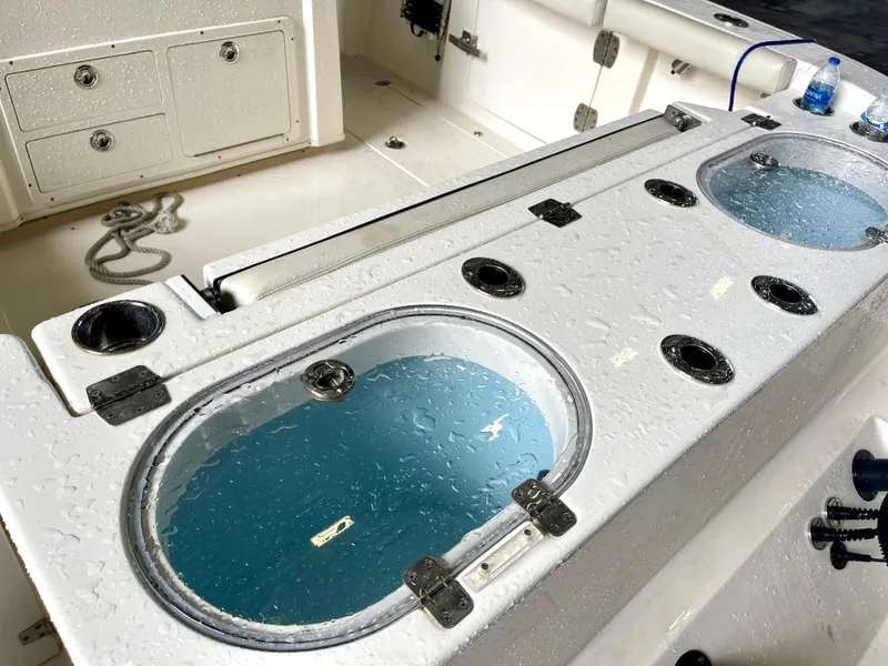 Slide: The Image of 2018 Cobia 301 Center Console boat with live wells and storage compartments. - 15