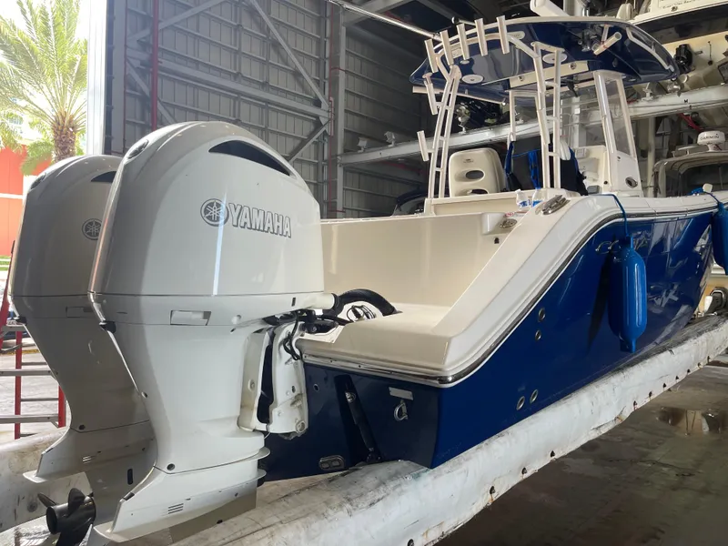 Slide: The Image of 2018 Cobia 301 Center Console boat with twin Yamaha engines in a storage facility. - 16