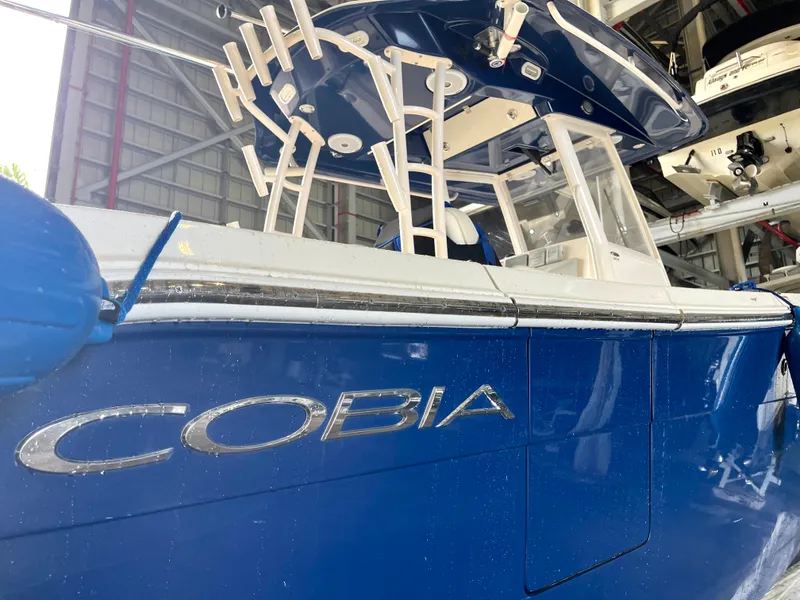 Slide: The Image of 2018 Cobia 301 Center Console boat in blue, docked in a marina. - 4