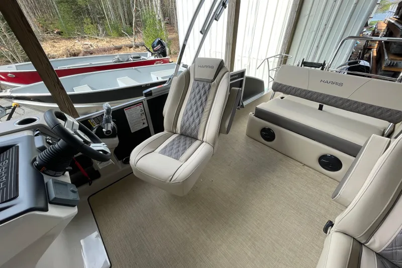 Slide: The Image of 2026 Harris Cruiser 210 interior with beige seating and steering console. - 13