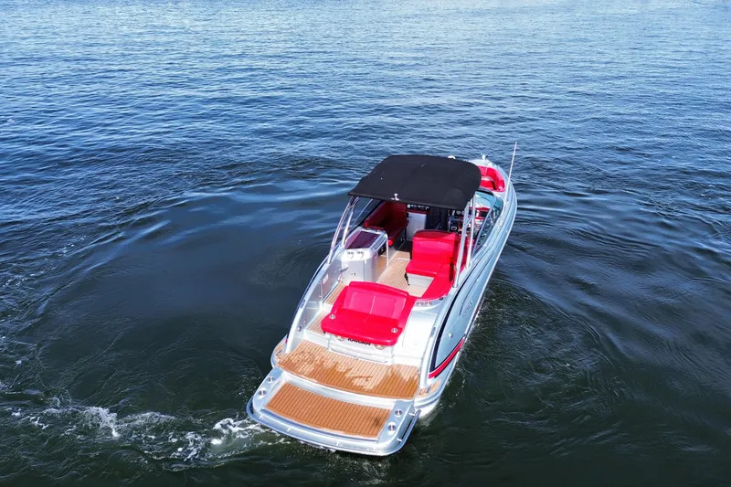 Slide: The Image of 2014 Formula 310 Bowrider boat with red seating on open water. - 14