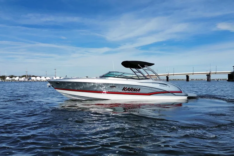 Slide: The Image of 2014 Formula 310 Bowrider boat on water, clear sky, bridge in background. - 2