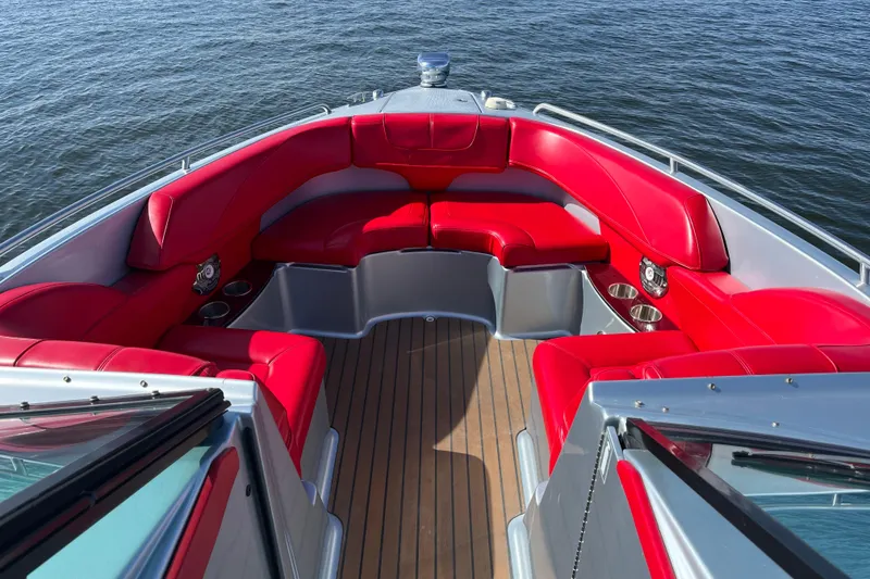 Slide: The Image of 2014 Formula 310 Bowrider with red seating, wooden deck, on calm water. - 31