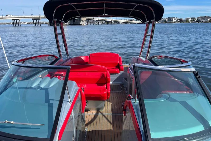 Slide: The Image of 2014 Formula 310 Bowrider with red seating, docked on calm water near a bridge. - 36
