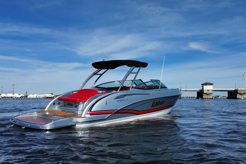 Slide: The Image of 2014 Formula 310 Bowrider boat on water, near a bridge, under a clear blue sky. - 6