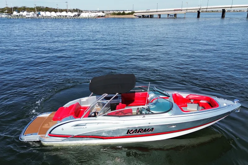 Slide: The Image of 2014 Formula 310 Bowrider boat with red seating on open water. - 7