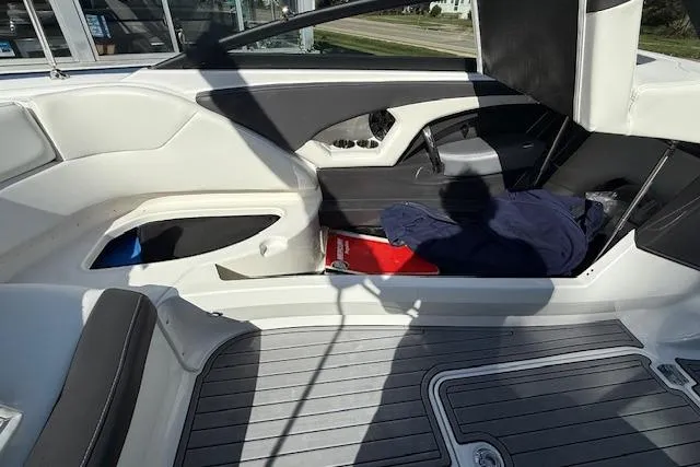 Slide: The Image of 2018 Monterey 224FS boat storage compartment with cooler, open lid, and sleek interior design. - 25