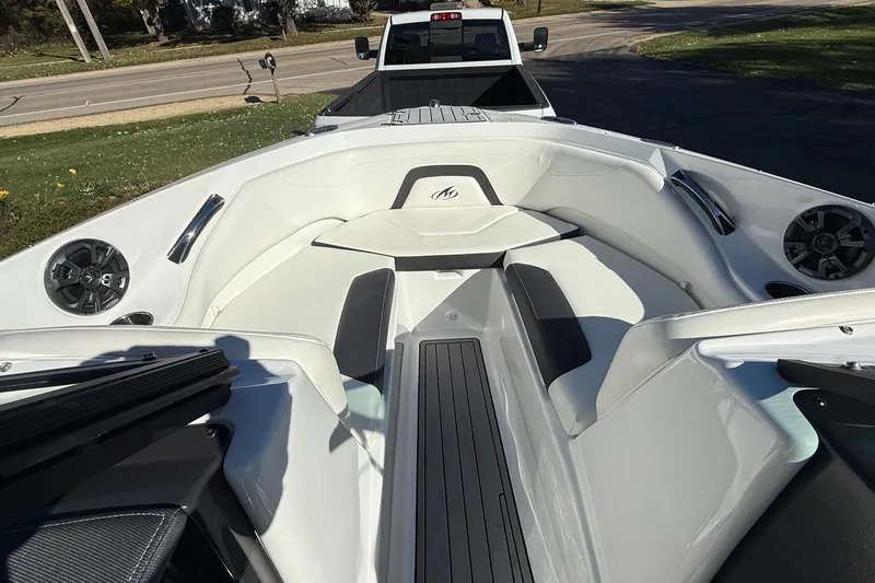 Slide: The Image of 2018 Monterey 224FS boat interior with white seating and speakers, parked on a trailer. - 43