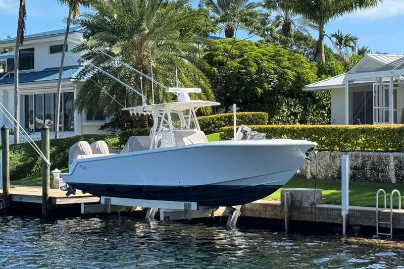 Slide: The Image of 2023 SeaVee 340Z boat docked by waterfront home with lush greenery. - 1