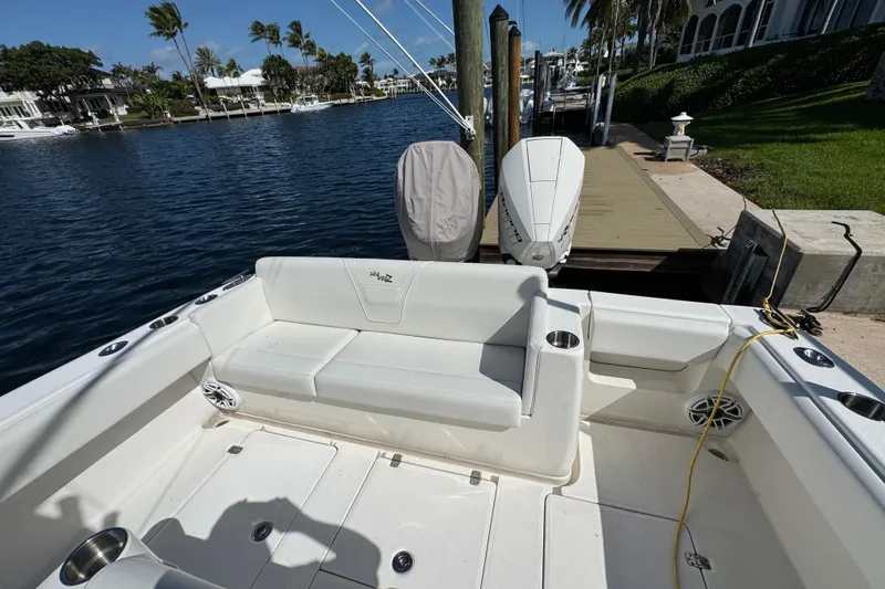 Slide: The Image of 2023 SeaVee 340Z boat docked, featuring spacious seating and dual outboard engines. - 17