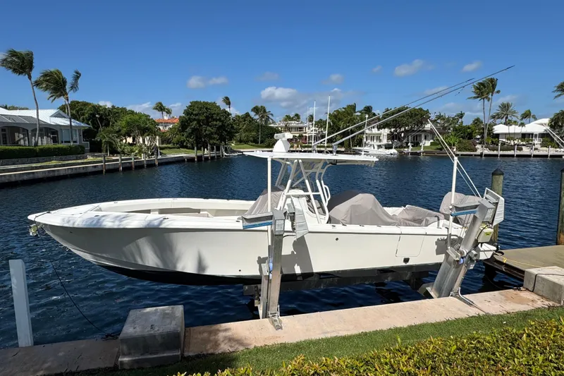 Slide: The Image of 2023 SeaVee 340Z boat docked by waterfront homes under clear blue sky. - 2