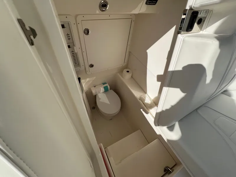 Slide: The Image of 2023 SeaVee 340Z boat interior bathroom with toilet and storage compartments. - 22