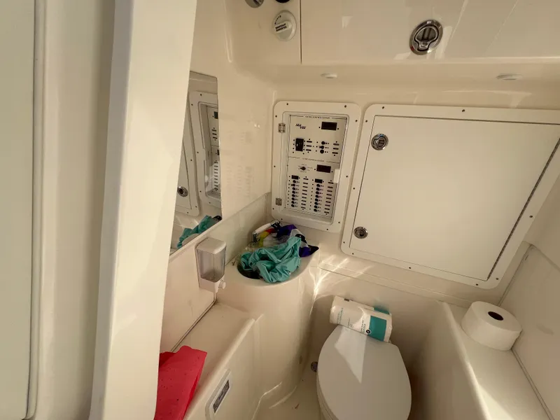 Slide: The Image of 2023 SeaVee 340Z boat bathroom with toilet, storage compartments, and control panel. - 23