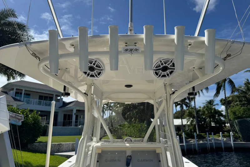 Slide: The Image of 2023 SeaVee 340Z boat with rod holders and speakers, docked near waterfront homes. - 25