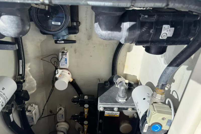 Slide: The Image of 2023 SeaVee 340Z engine compartment with various mechanical components and hoses. - 26