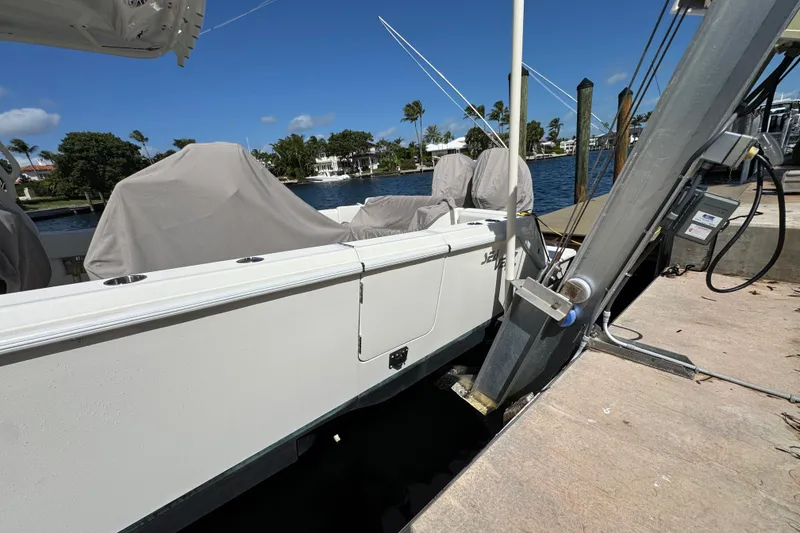 Slide: The Image of 2023 SeaVee 340Z boat docked, covered, with scenic waterfront view. - 29