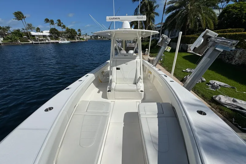 Slide: The Image of 2023 SeaVee 340Z boat docked by waterfront, featuring spacious deck and seating. - 5