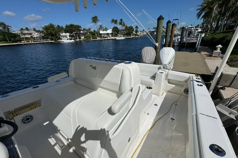 Slide: The Image of 2023 SeaVee 340Z boat docked, featuring spacious seating and scenic waterfront view. - 9