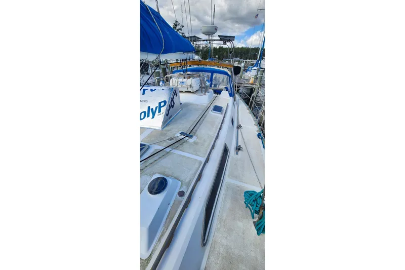 Slide: The Image of 1980 Nordic 44 sailboat deck with blue canopy and marina background. - 13