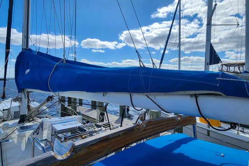 Slide: The Image of Sailboat Nordic 44 (1980) docked, blue sail cover, clear sky, calm water. - 16