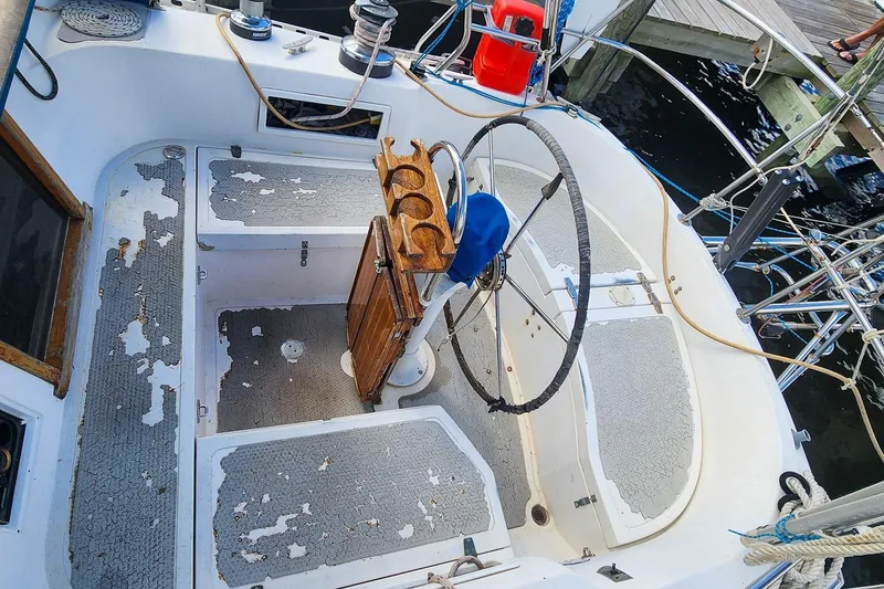 Slide: The Image of Cockpit of a 1980 Nordic 44 sailboat with weathered flooring and steering wheel. - 19