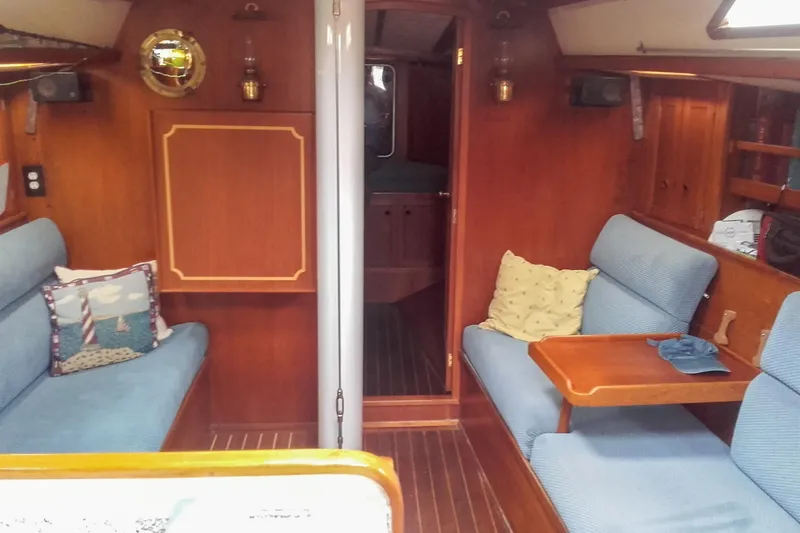 Slide: The Image of Cozy interior of a 1980 Nordic 44 sailboat with blue seating and wooden accents. - 27