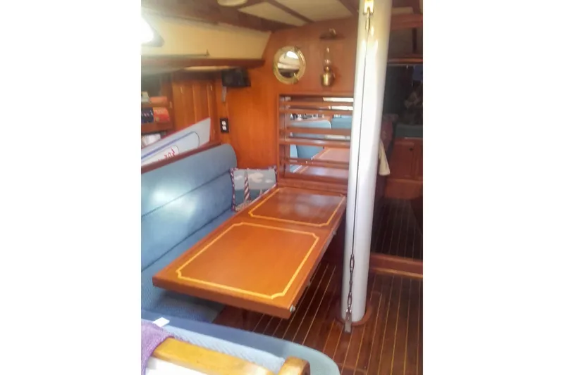 Slide: The Image of Interior of 1980 Nordic 44 sailboat with wooden table and blue seating. - 28