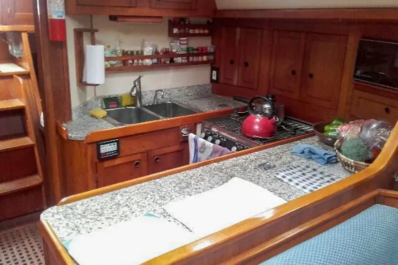 Slide: The Image of Cozy kitchen in 1980 Nordic 44 sailboat with wooden cabinets and granite countertops. - 29
