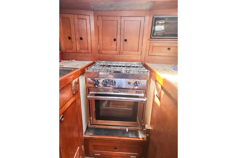 Slide: The Image of 1980 Nordic 44 yacht kitchen with wooden cabinets and stainless steel stove. - 30