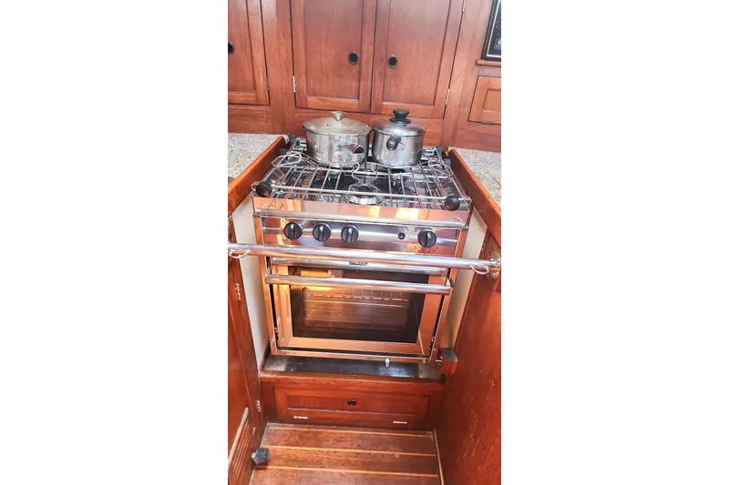 Slide: The Image of Vintage Nordic 44 yacht kitchen with stove and pots, featuring wooden cabinetry, 1980 model. - 31
