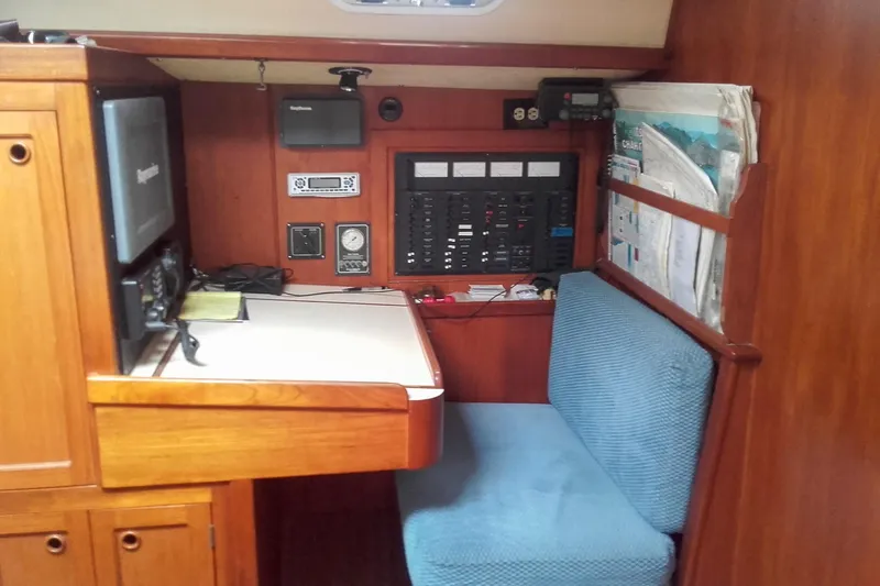 Slide: The Image of Navigation station in a 1980 Nordic 44 sailboat with control panels and seating. - 32
