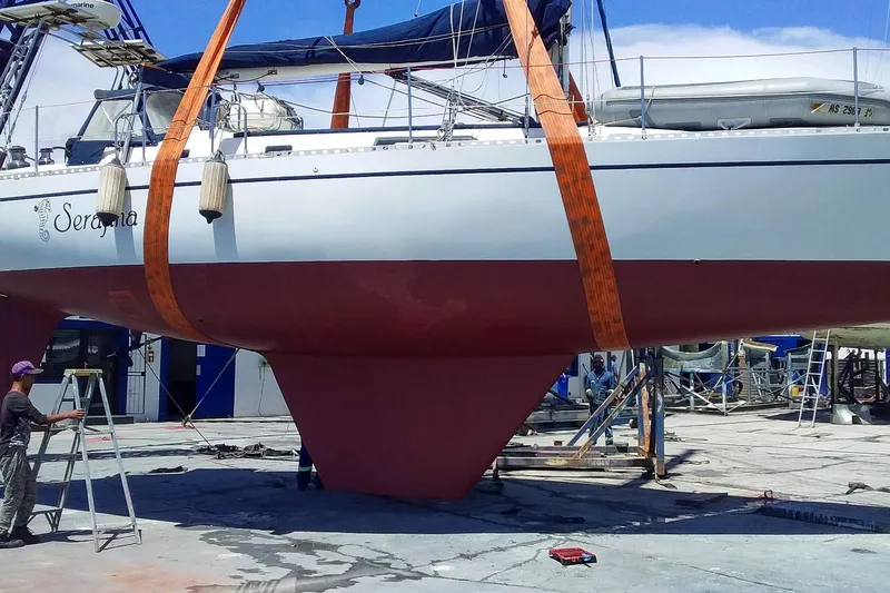 Slide: The Image of Sailboat Nordic 44 from 1980 in dry dock, undergoing maintenance with visible keel and straps. - 38