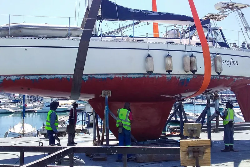 Slide: The Image of Nordic 44 sailboat from 1980 being lifted at a marina with workers in safety vests. - 39