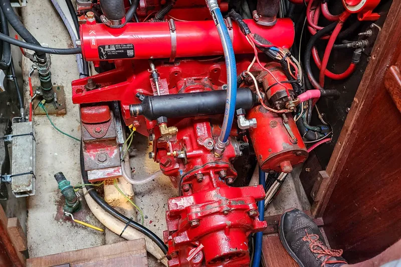 Slide: The Image of Engine compartment of a 1980 Nordic 44 sailboat, featuring red mechanical components and wiring. - 47