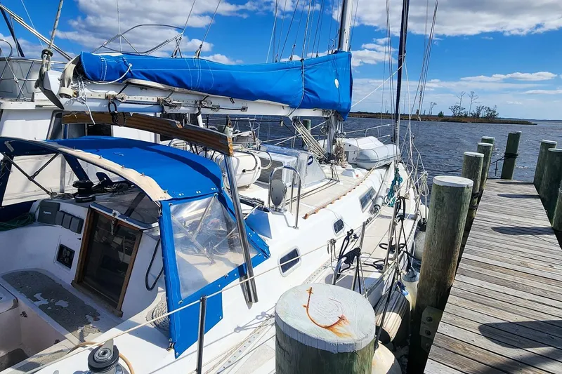 Slide: The Image of 1980 Nordic 44 sailboat docked, featuring blue covers and clear skies. - 9