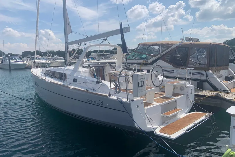 The Image of 2016 Beneteau Oceanis 38 sailboat docked in a sunny marina. - 0