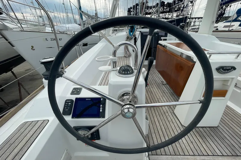 Slide: The Image of Steering wheel of a 2016 Beneteau Oceanis 38 sailboat, featuring navigation instruments. - 12