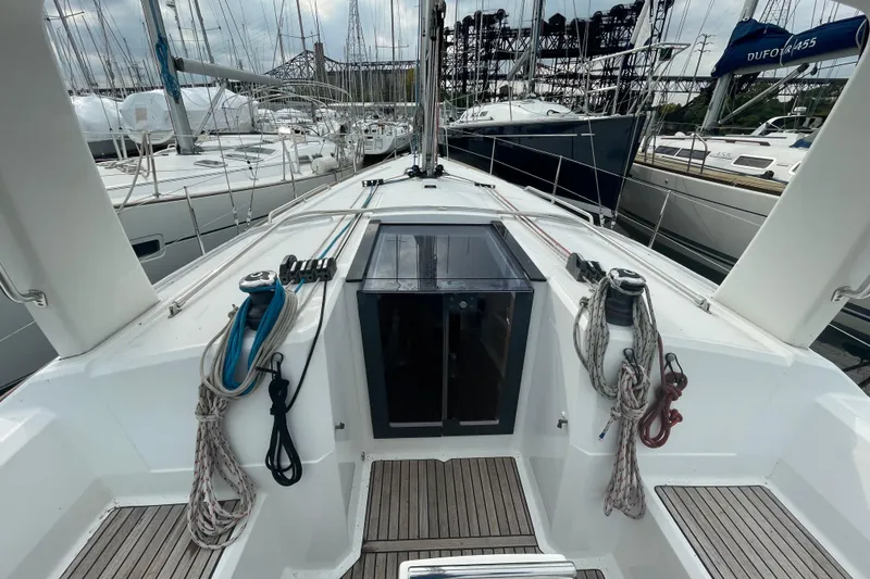 Slide: The Image of 2016 Beneteau Oceanis 38 sailboat deck with ropes and winches in marina setting. - 17