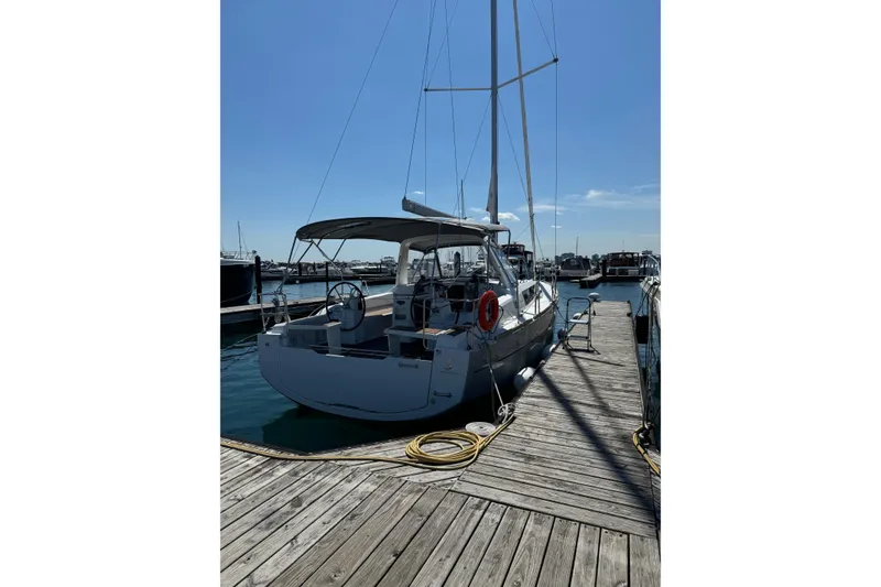 Slide: The Image of 2016 Beneteau Oceanis 38 sailboat docked at marina under clear blue sky. - 2