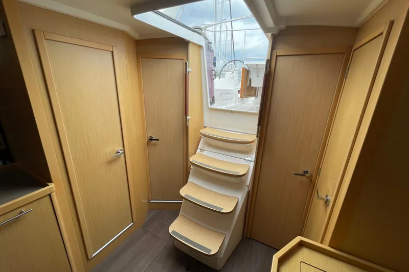 Slide: The Image of Interior of 2016 Beneteau Oceanis 38 sailboat with wooden doors and staircase to deck. - 23