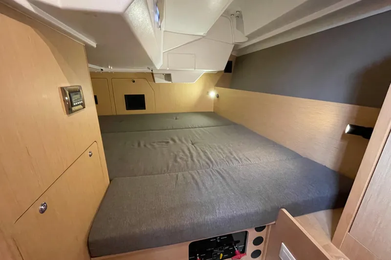 Slide: The Image of Interior cabin of 2016 Beneteau Oceanis 38 sailboat with cozy bedding and wooden finish. - 27