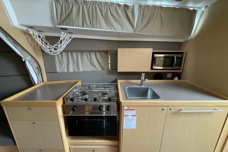 Slide: The Image of Compact kitchen in 2016 Beneteau Oceanis 38 yacht with stove, sink, and microwave. - 29
