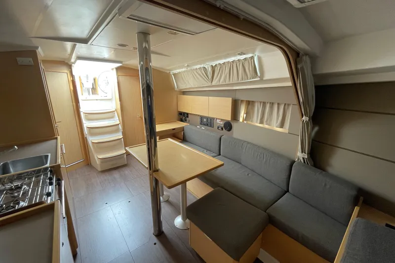 Slide: The Image of Interior of 2016 Beneteau Oceanis 38 yacht, featuring modern kitchen and cozy seating area. - 34