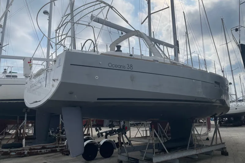 Slide: The Image of 2016 Beneteau Oceanis 38 sailboat on dry dock, surrounded by other yachts. - 4