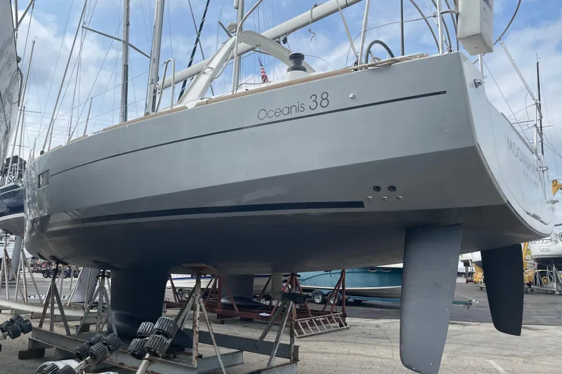 Slide: The Image of 2016 Beneteau Oceanis 38 sailboat on dry dock, showcasing sleek hull design. - 5