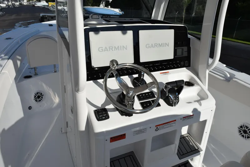 Slide: The Image of 2026 Sea Hunt Ultra 265 SE boat dashboard with Garmin navigation displays. - 8