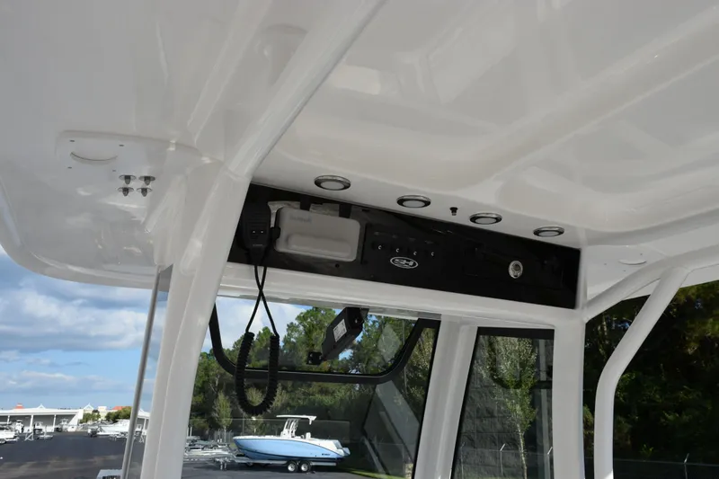 Slide: The Image of 2026 Sea Hunt Ultra 265 SE boat interior with control panel and overhead storage. - 9