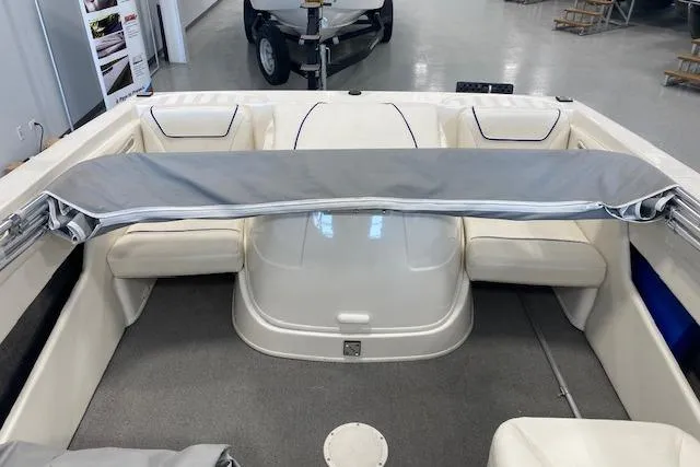 Slide: The Image of 2012 Bayliner 195 Discovery boat interior with seating and cover in showroom. - 10