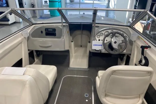 Slide: The Image of 2012 Bayliner 195 Discovery boat interior with steering wheel, dashboard, and seating. - 12